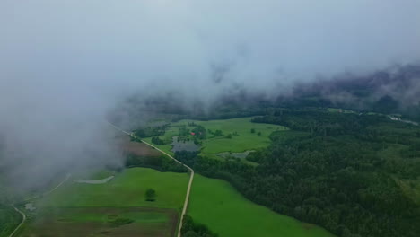 Vista-De-Drones-De-Nubes-Ondulantes-Sobre-Un-Exuberante-Paisaje