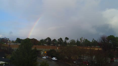 4k aerial drone footage of studio city, ca with rain, cloudy skies and a rainbow