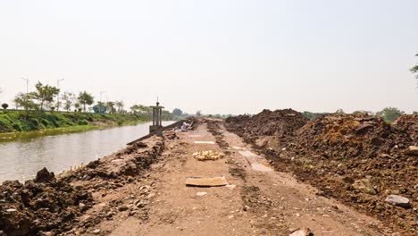 dirt path beside waterway under construction