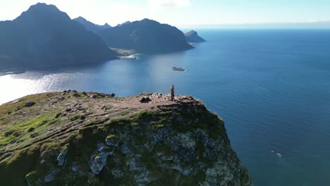 vista aérea en órbita de dos personas en órbita en lofoten, noruega, con vistas a muchas montañas y fiordos circundantes