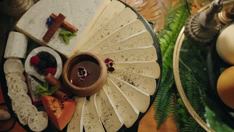 elegant cheese board with assorted fruit cinnamon sticks and chocolate dip