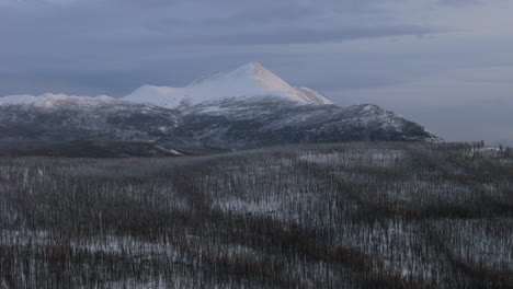 a frosty aerial expedition soars over yukon’s ibex valley at golden hour. snow-laden trees, icy rivers, and towering mountains merge under a warm sunset glow, capturing raw winter beauty.