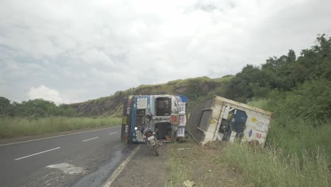 Un-Camión-Que-Transportaba-Un-Contenedor-De-Almacenamiento-En-Frío-Se-Volcó-En-Un-Accidente-Debido-A-Un-Sobreviraje-En-Una-Sección-Ghat-Cuesta-Abajo-En-Una-Carretera-India-En-Cámara-Lenta-De-4k