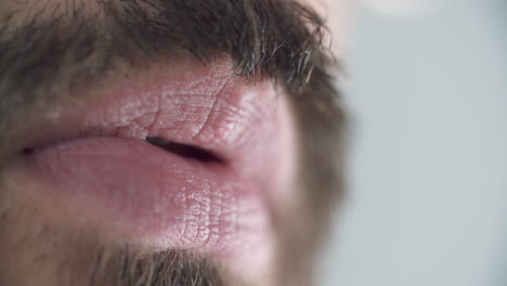 macro shot of a caucasian man moving his mouth and forming different sounds with lips