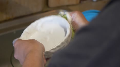 primer plano manos caucásicas lavando platos en el fregadero de la cocina