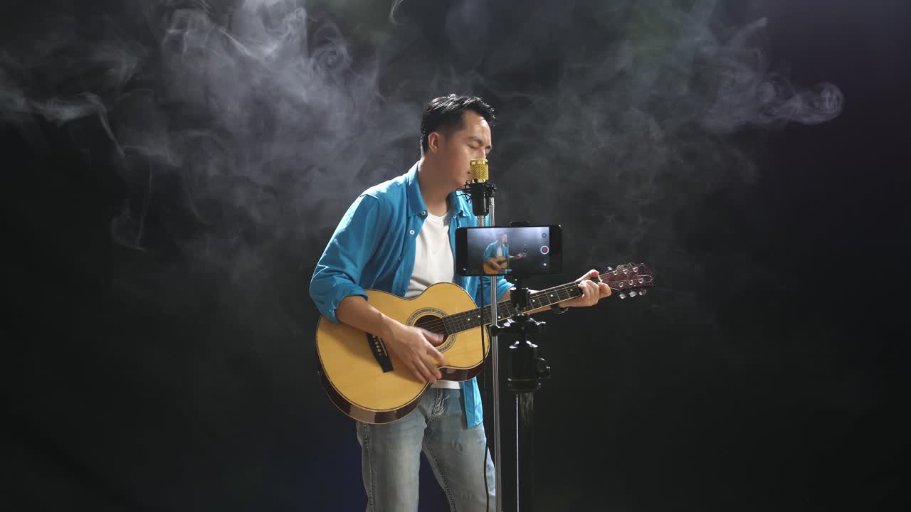 hombre cantando y tocando la guitarra acústica