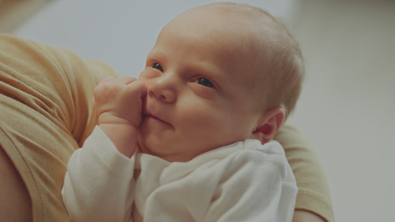 Baby sover i foreldres armer