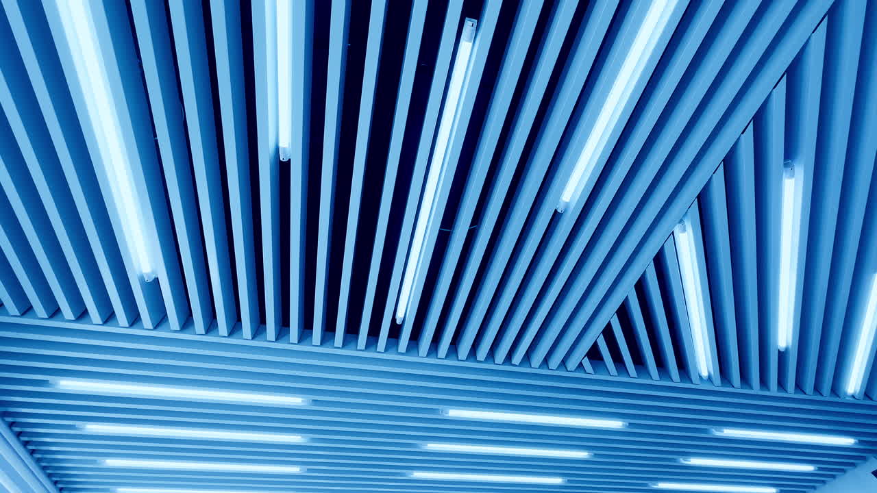 Embossed plank ceiling with bright illumination. Led lamps of day light from low angle perspective.