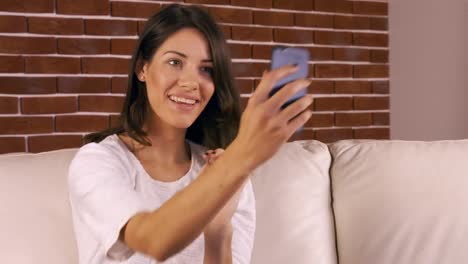 Mujer-Sonriente-Tomando-Selfie-En-El-Sofá-