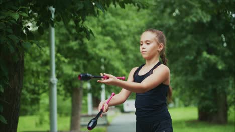 A Young Girl Perfecting Her Juggling Skills with Graceful Control and Focus in a Lush Green Park Setting, Showcasing Dedication to the Art of Performance