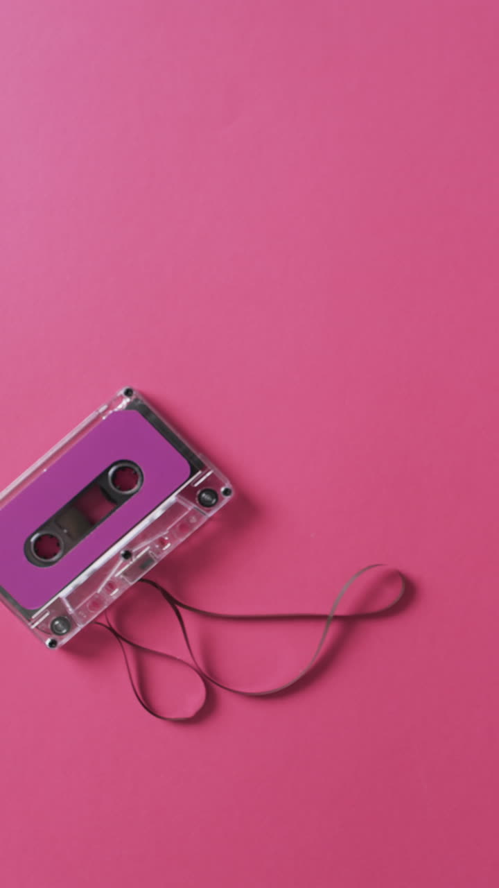 Vertical video of retro tape with pink label and copy space on pink background
