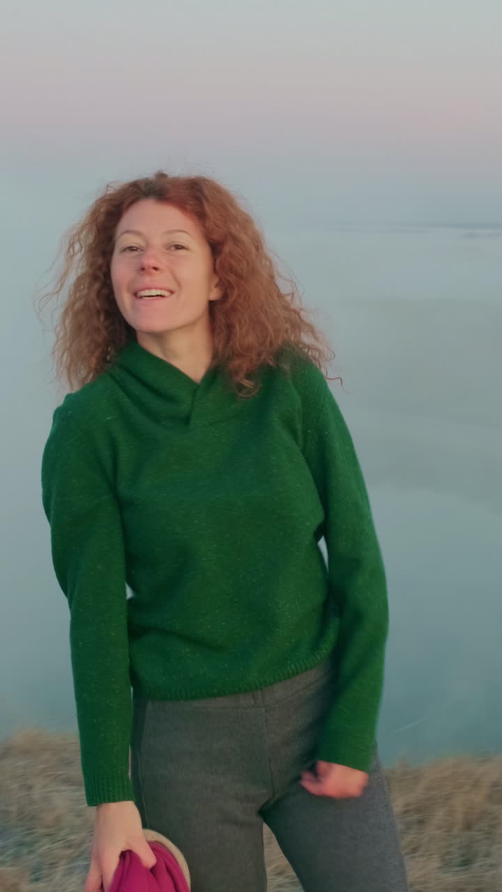 Smiling Woman in a Green Sweater at Sunset