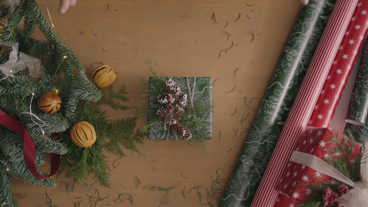 하향식 계획. 장식이 있는 테이블이 완전히 보입니다. 나무 테이블 위에 공예 종이로 싸인 크리스마스 선물. 붕대 테이프와 묶인 활.