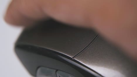 man presses button and shakes mouse on white surface macro