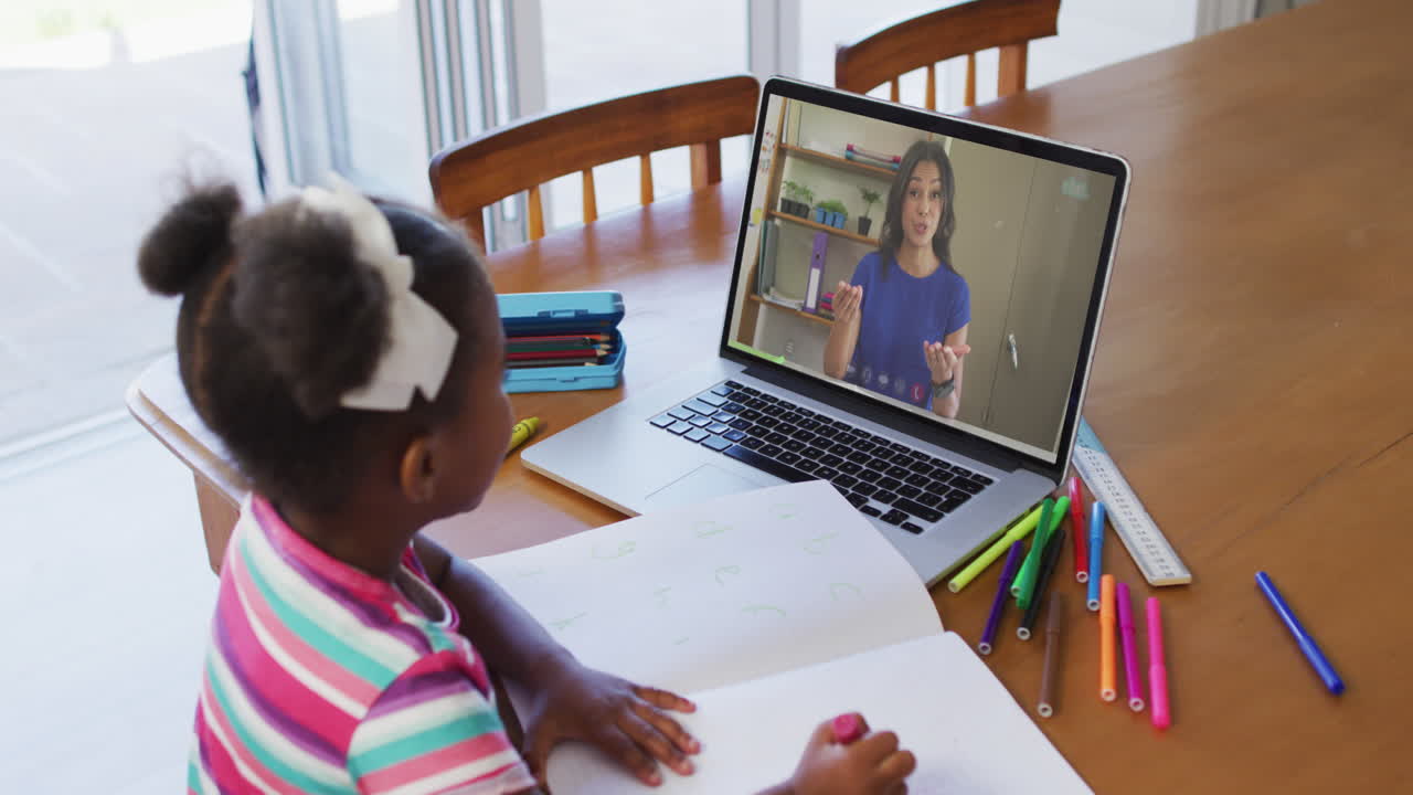 African american girl sitting at desk using laptop having online school lesson