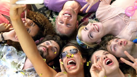 animación de confeti cayendo sobre amigas acostadas en la hierba tomando selfies en el campamento de verano