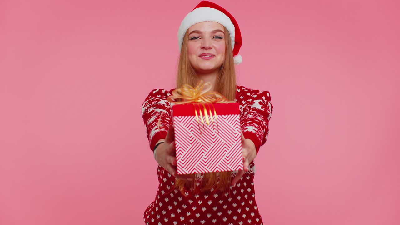 chica alegre en suéter de navidad rojo con ciervos presentando caja de regalos de navidad, compras venta de vacaciones