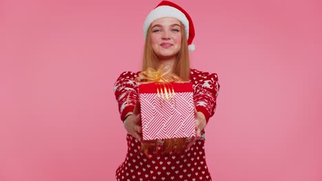 chica alegre en suéter de navidad rojo con ciervos presentando caja de regalos de navidad, compras venta de vacaciones