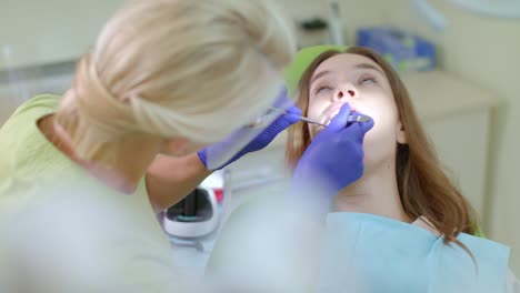 patient with toothache sitting in dentist chair. dentist working with girl