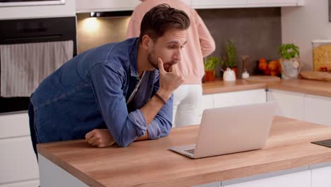 couple using laptop in the kitchen