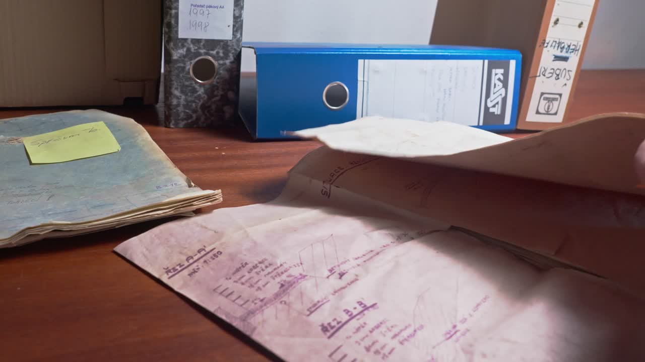 Admin clerk searches old paper document business records on office desk