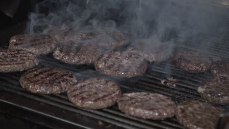 la carne de la hamburguesa está a la parrilla en bbq a cámara lenta con humo