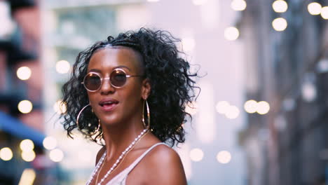 young black woman dancing and singing on the street, low angle, bokeh lights in background