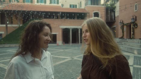 dos mujeres hablando en una plaza de la ciudad