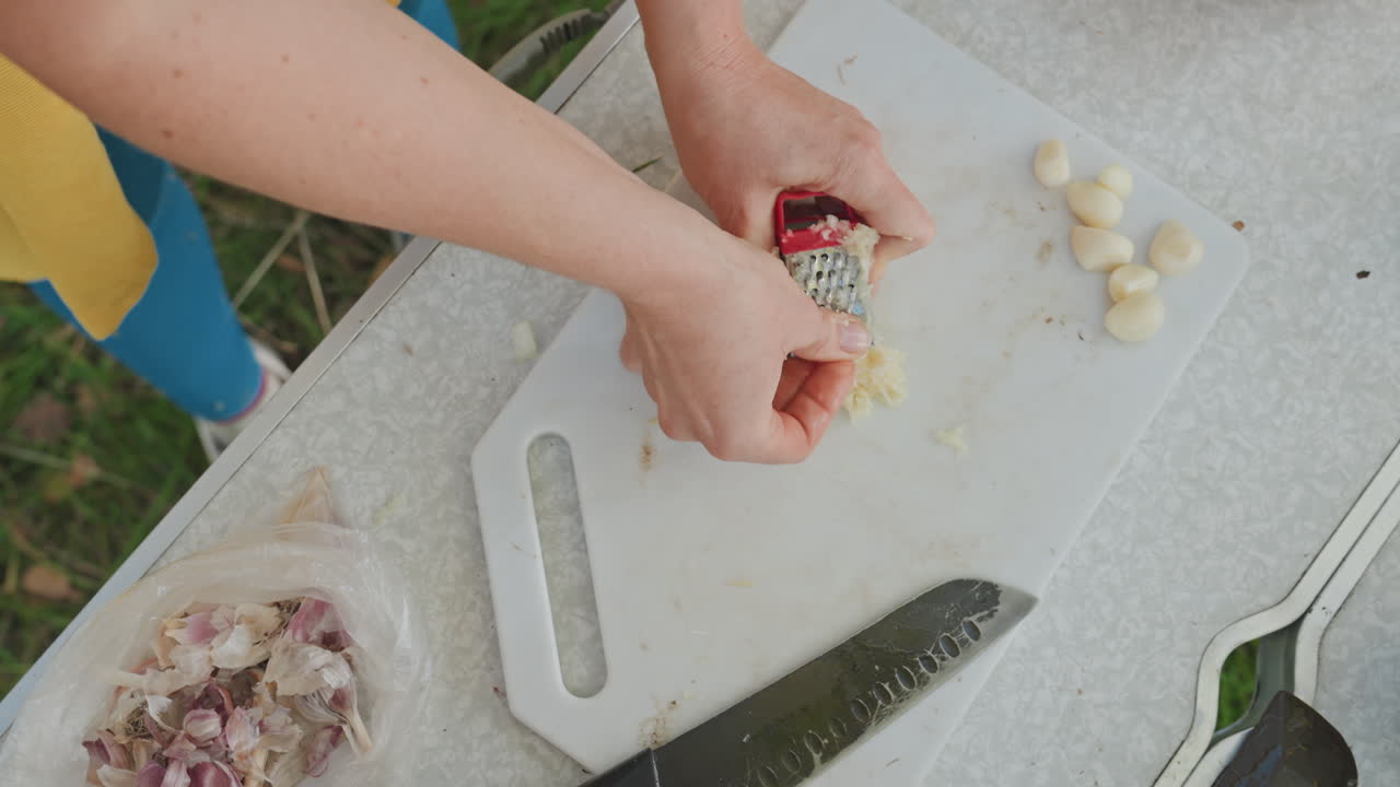 Scena di preparazione per il campeggio. Preparazione dello stufato da falò all'aperto. Organizzarsi per cucinare nella natura con ingredienti freschi. Scena esterna rilassata con verdure da tagliare e provviste per cucinare da raccogliere