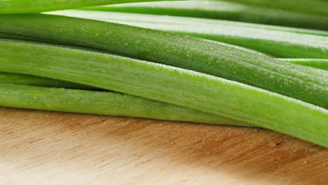 fresh green onions on wooden cutting board