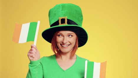 mujer con sombrero sosteniendo banderas irlandesas