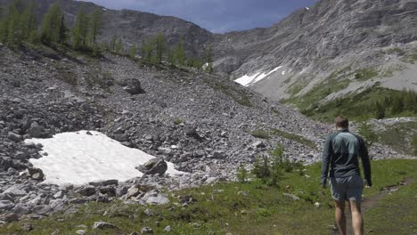 Wanderer,-Der-Den-Trail-Pan-Tilt-Zum-Berg-Hinuntergeht,-Rockies,-Kananaskis,-Alberta,-Kanada