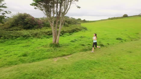 Mujer-En-Forma-Corriendo-En-Un-Paisaje-Verde