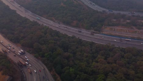 multi lane pune mumbai expressway carved through the mountain valley, lonavala, maharashtra, revealing drone shot