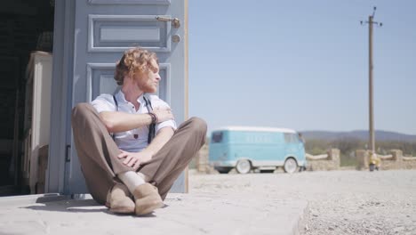 man sitting outdoors near a door