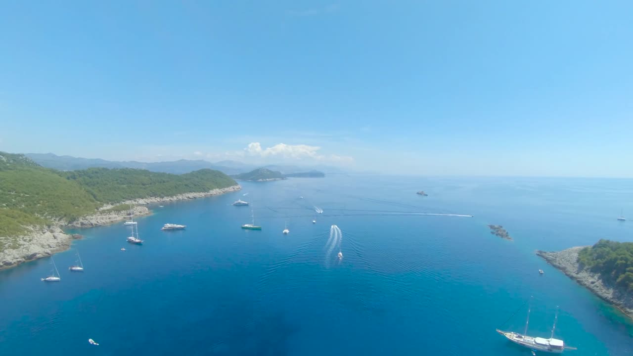 Aerial Drone Footage heading over Boats and out to Sea from the Beach of Sunj Bay, Lopud, Croatia.