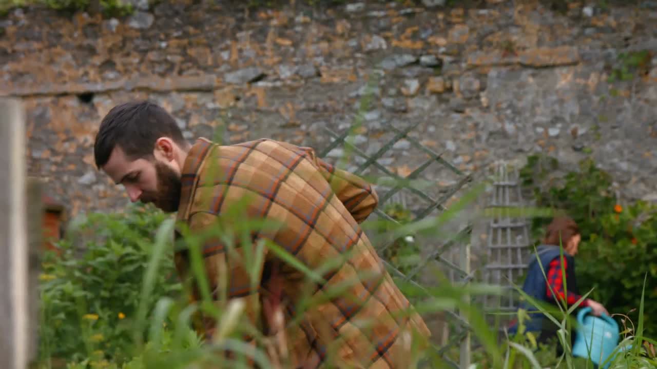 예쁜 젊은 남자가 정원 가꾸고 있습니다.