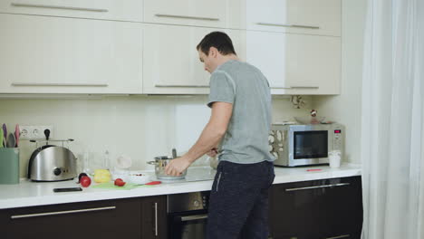 hombre enojado hablando por teléfono en la cocina. hombre infeliz con las manos cruzadas.