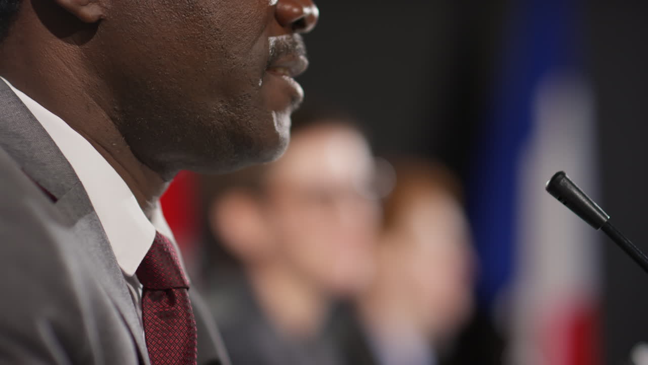 Uomo afroamericano che parla al microfono a una conferenza stampa politica