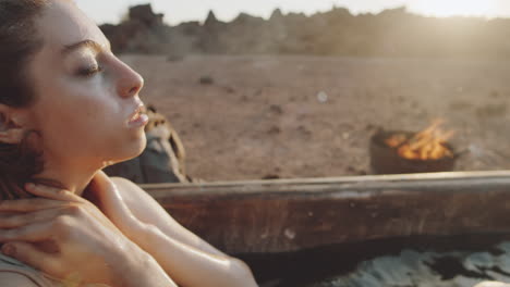 woman lying in bath with dirty water in dystopian world