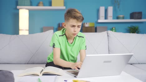 boy working on computer at home. he's talking to himself.