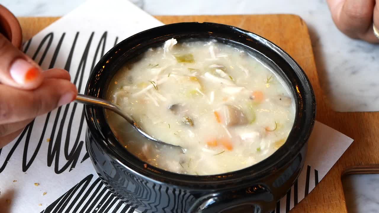 человек ест куриный суп.