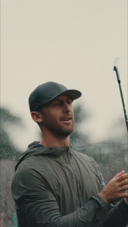 Un-Golfista-Masculino-Observa-Un-Chip-Shot-Con-Un-Giro-Del-Palo-Bajo-Una-Lluvia-Torrencial-En-Cámara-Lenta