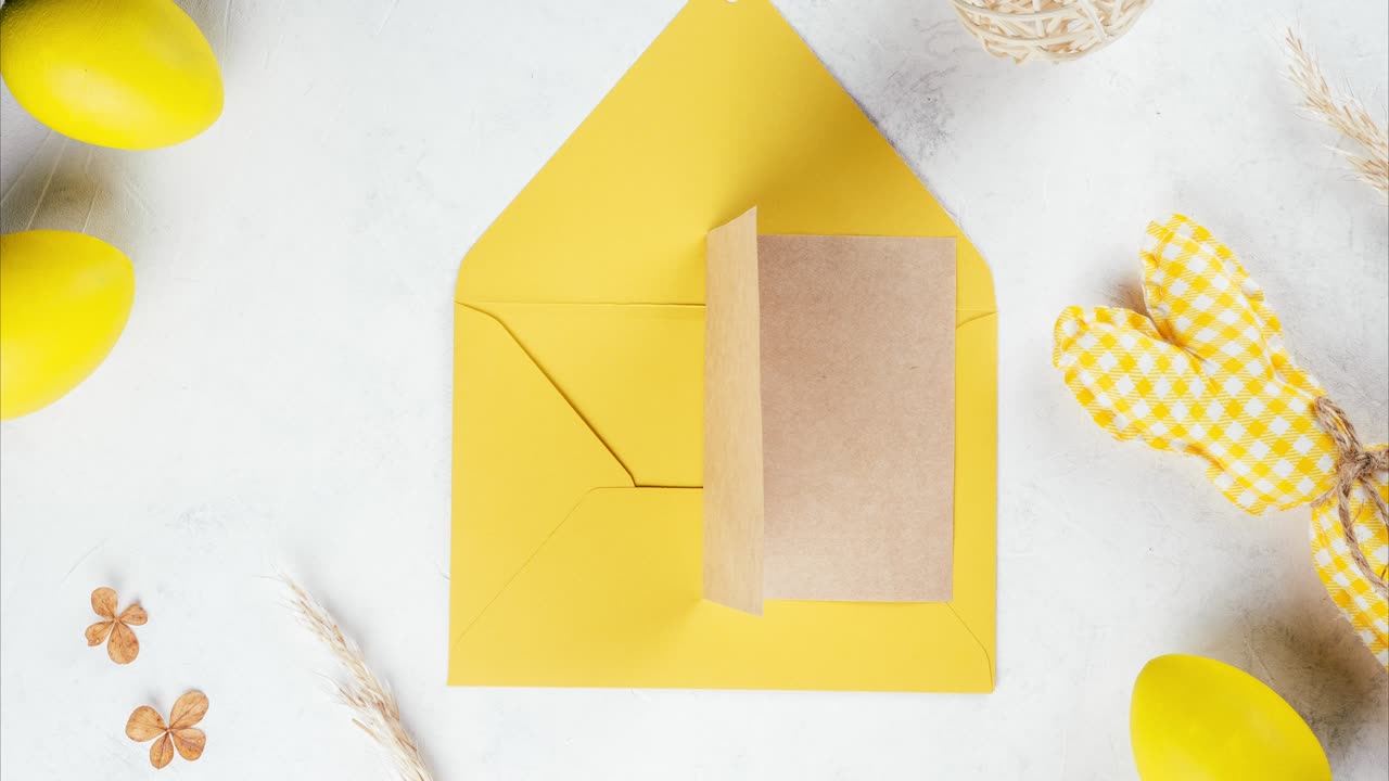 Stop motion Easter video of yellow opening envelope with toy bunny and eggs. Paper card taken out and open. Copy space