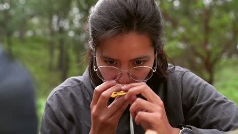 Woman-smelling-pine-bolete-mushroom-in-woods