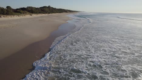 foamy waves splashing sandy shore of coolum beach in sunshine coast region, queensland, australia - aerial drone shot