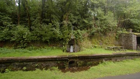 Extra-Wide-shot-of-Rainwater-being-funnelled,-controlled-under-the-platform-at-Cynonville-Station