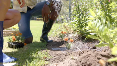 watering garden plants, person in boots tending to flowers outdoors