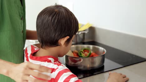 cute boy trying to cook with his mom