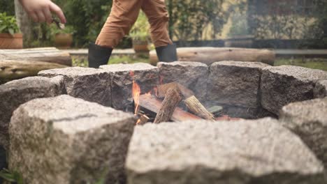 feeding the campfire flame with leaves